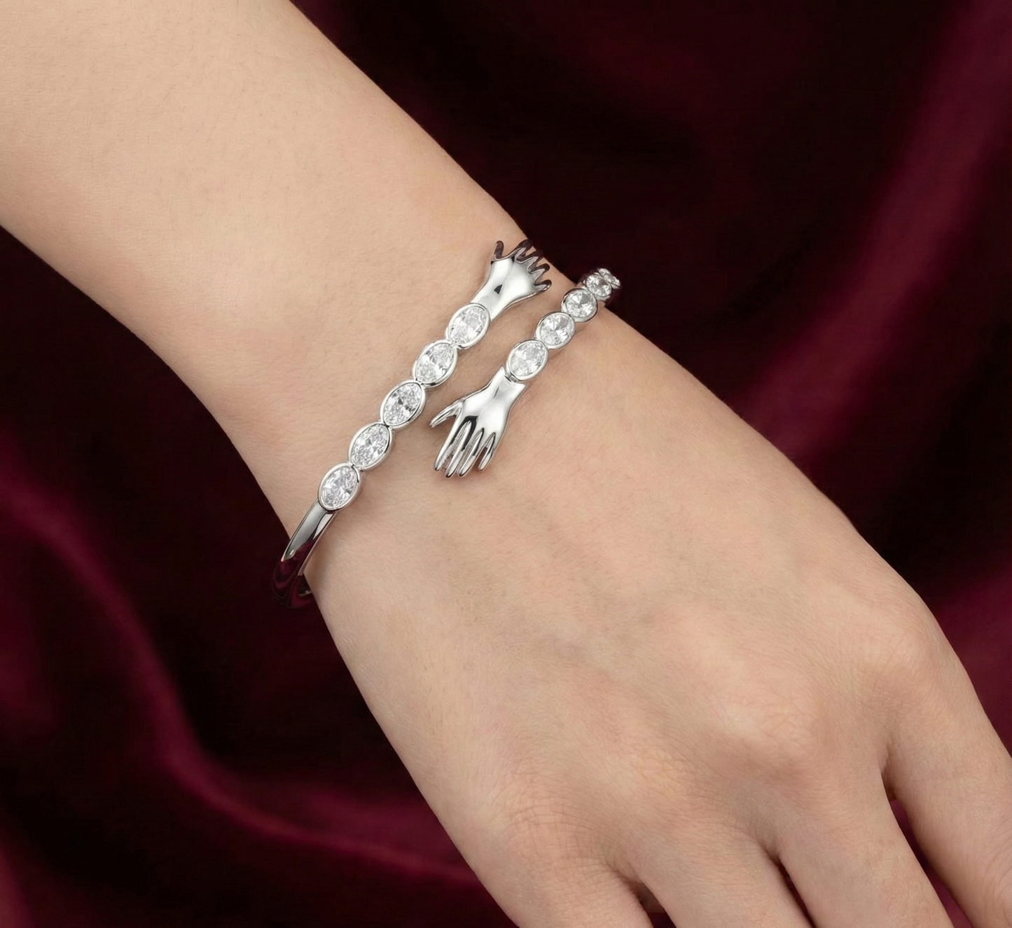 Silver bracelet with decorative elements on a wrist against a dark red background