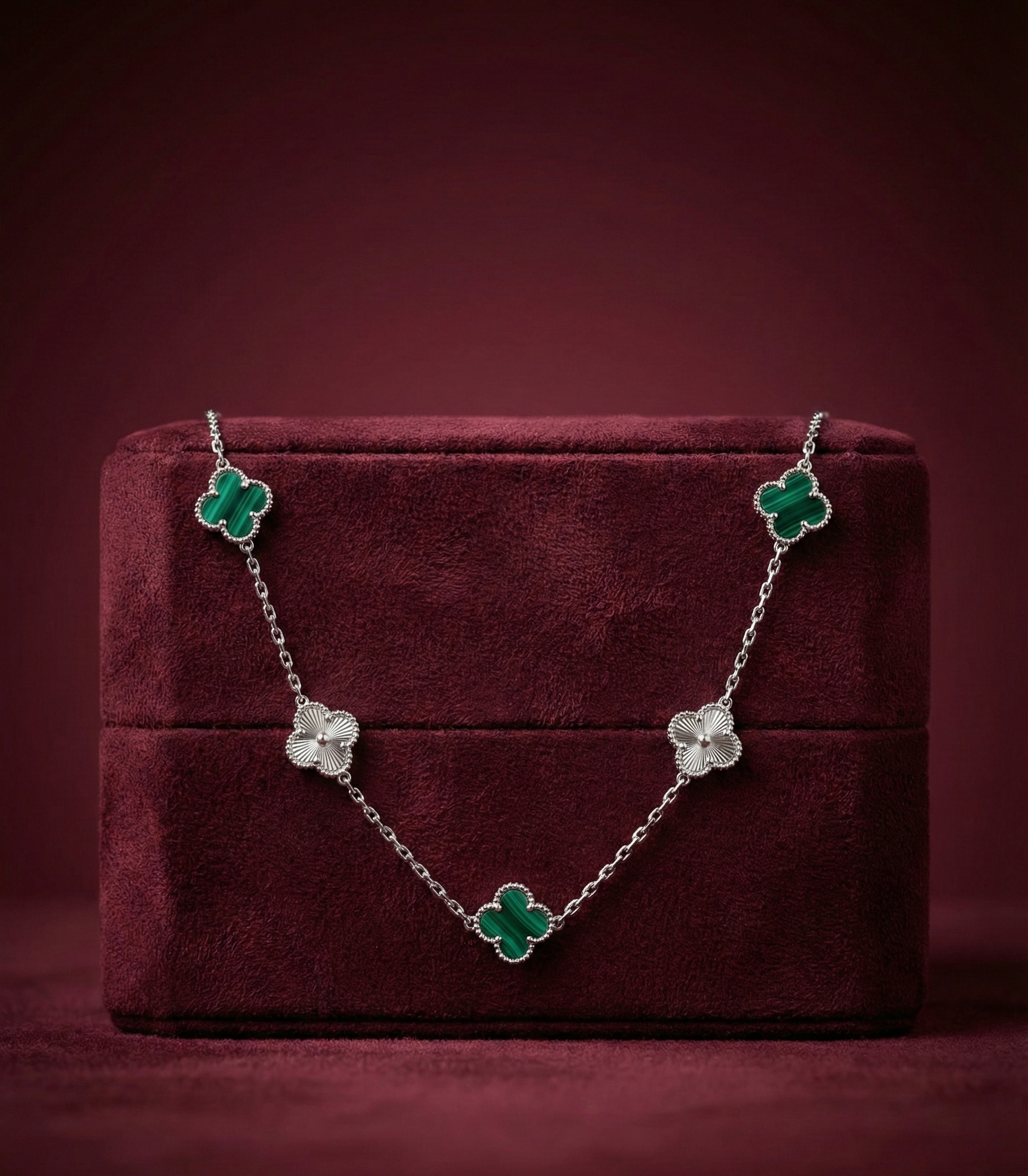 Floral necklace on a burgundy jewelry box with a dark red background