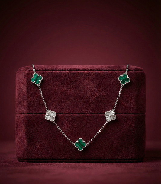 Floral necklace on a burgundy jewelry box with a dark red background