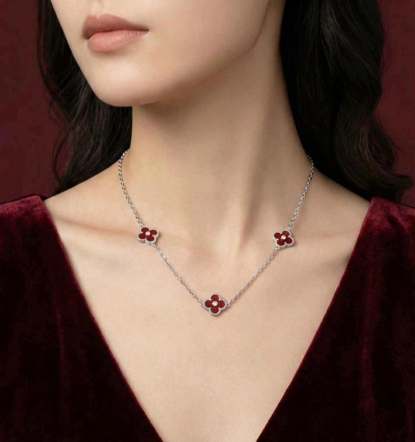 Necklace with floral pendants on a model wearing a dark red garment.