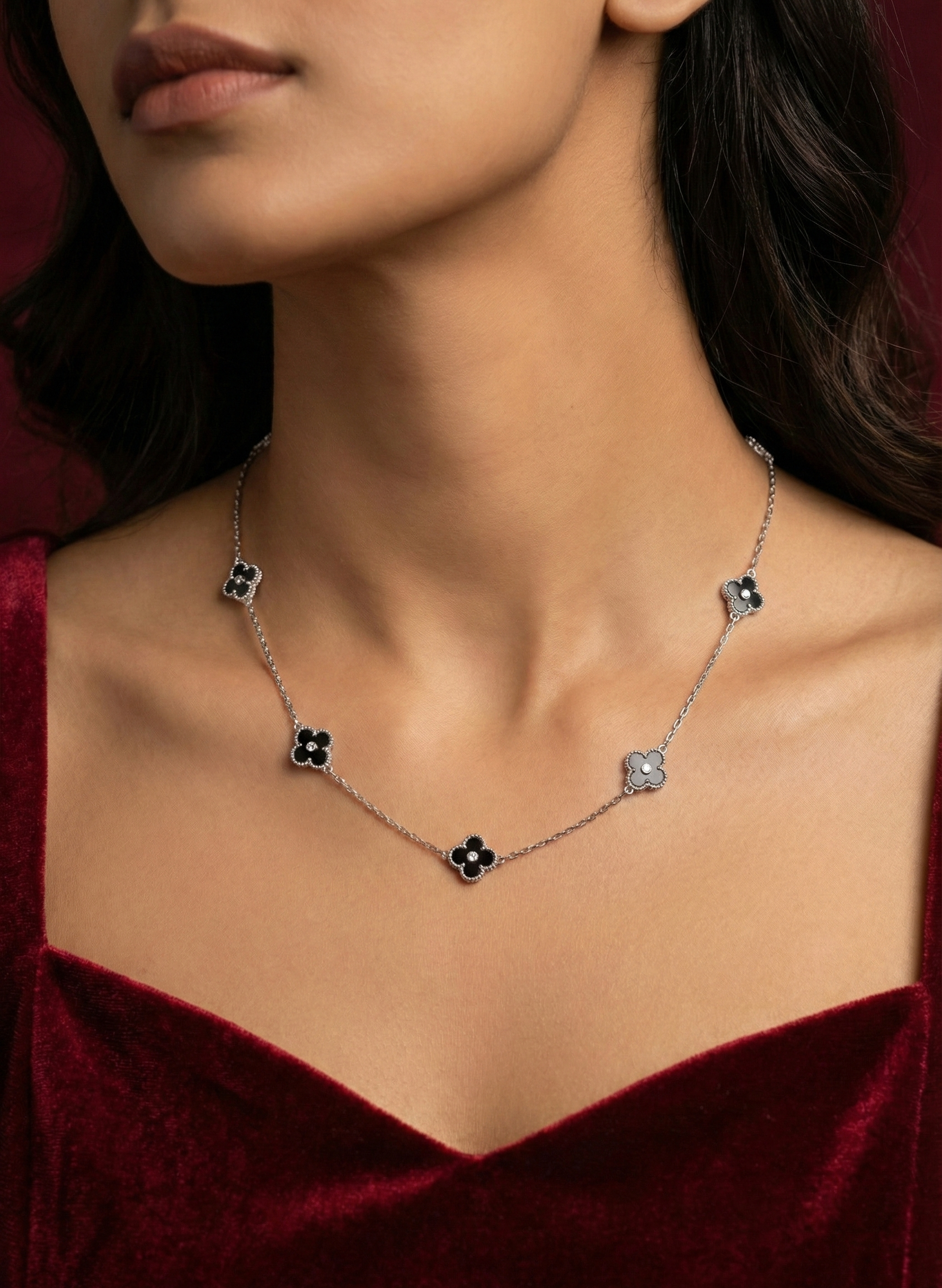 Necklace with floral pendants on a model wearing a red velvet garment.